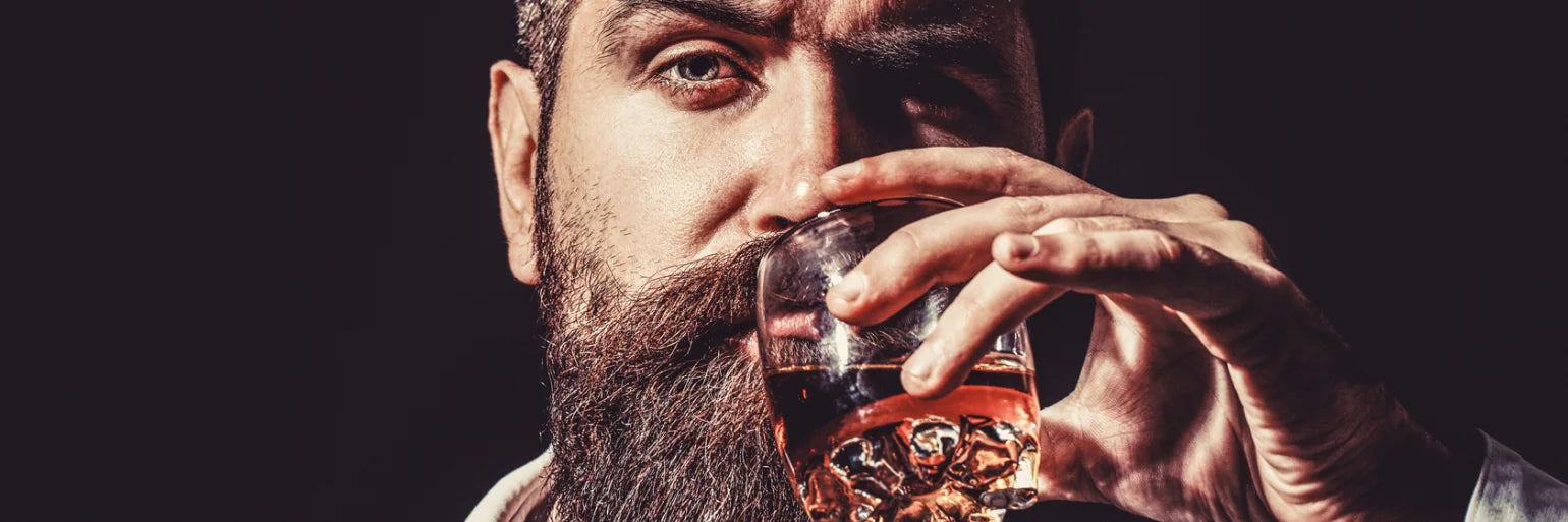 Mann trinkt Whisky aus Glas