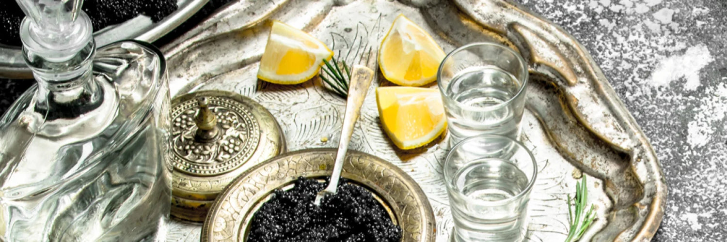 Vodka mit Kaviar und Zitronen sowie Stamperl Gläsyer auf Tablett