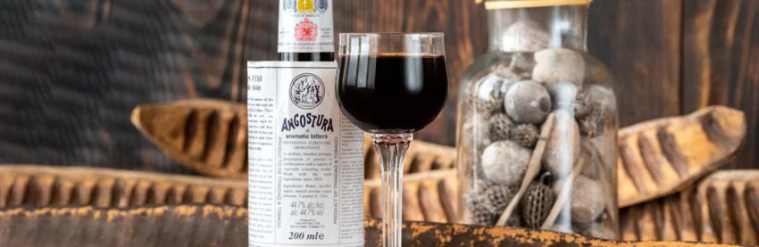 Angostura Bitter mit Dekoration und gefülltem Glas auf braunem Hintergrund