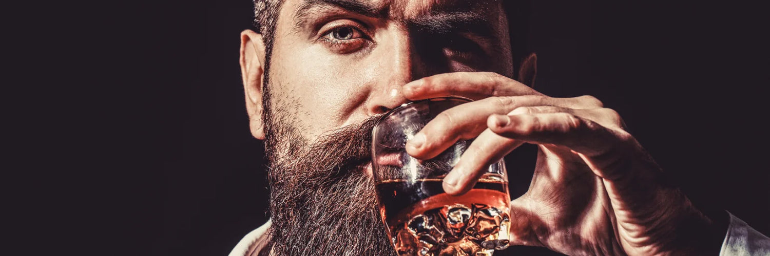 Mann trinkt Whisky aus Glas