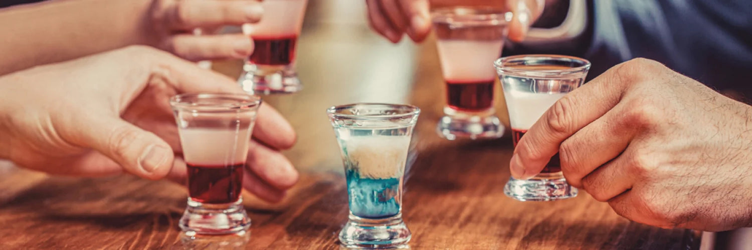 Hände mit Shot Gläser