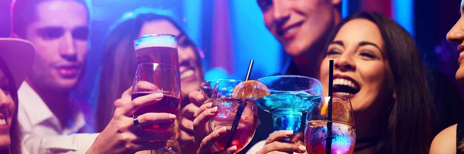 Menschen mit Getränken lachend auf buntem Hintergrund