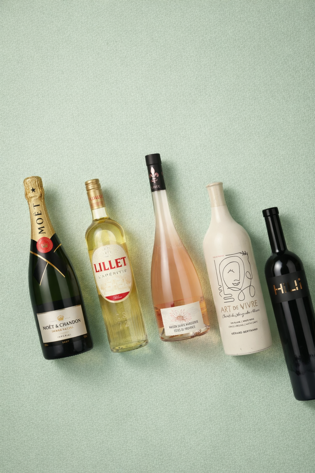 Schaumwein-, Aperitif- und Weinflaschen auf grünem Hintergrund.