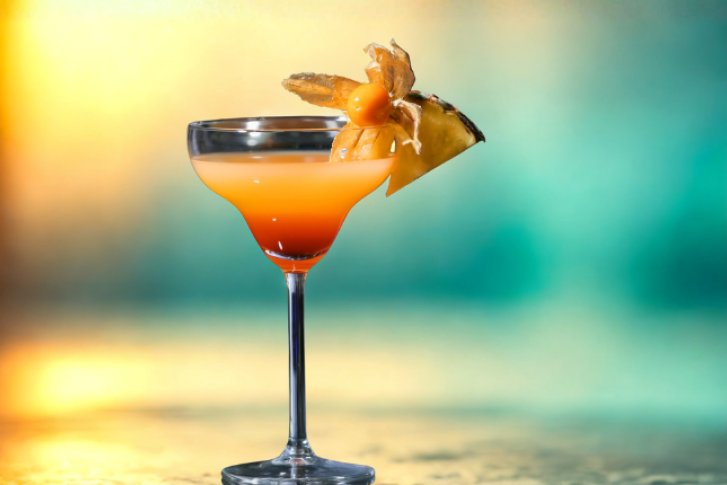 Bild zeigt Sex on the Beach cocktail auf farbenfrohen Hintergrund 