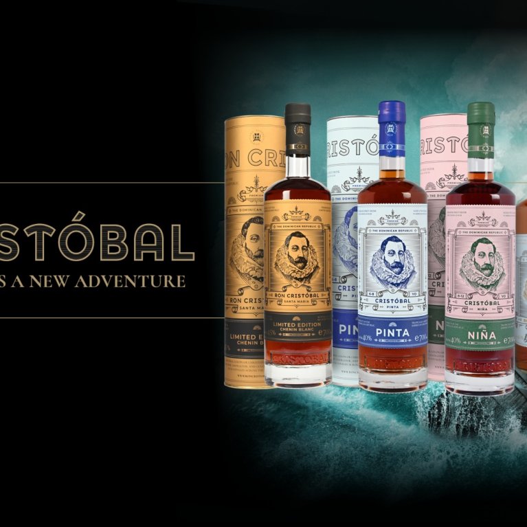 Différentes bouteilles de rhum sont alignées avec, en arrière-plan, une mer et un bateau.