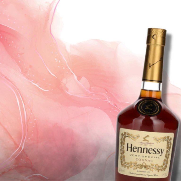 Eine Flasche Hennessy Very Special Cognac liegt leicht geneigt vor einem abstrakten, roséfarbenen Hintergrund mit fließenden Aquarellstrukturen – edel und modern inszeniert.
