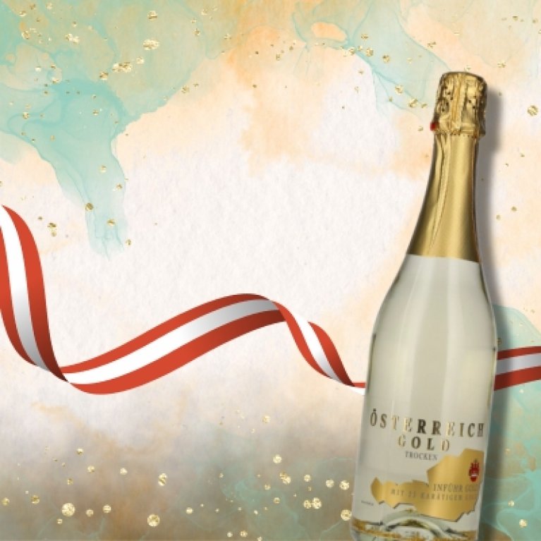 Fles "Österreich Gold Trocken" met gouden folie en banderol van de Oostenrijkse vlag tegen een feestelijke achtergrond in goud- en pasteltinten - symboliseert sprankelend genot van Oostenrijkse oorsprong.