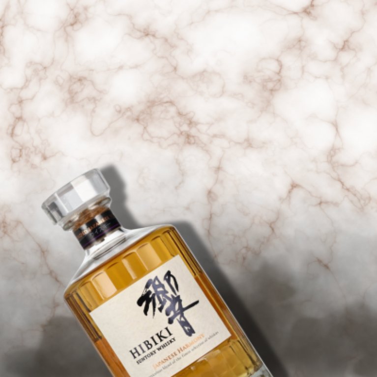 Whisky bottle in front of a marble background.