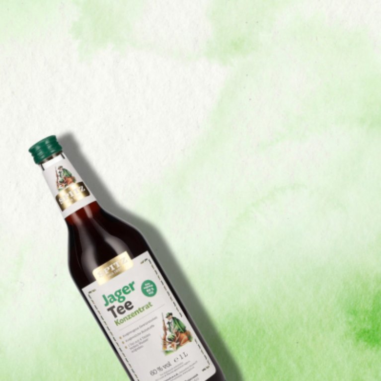 Flasche Jagertee-Konzentrat mit hellem Etikett, stehend auf einem hellen Hintergrund.