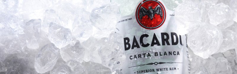La bouteille de Bacardi est refroidie dans la glace, entourée de nombreux glaçons transparents.