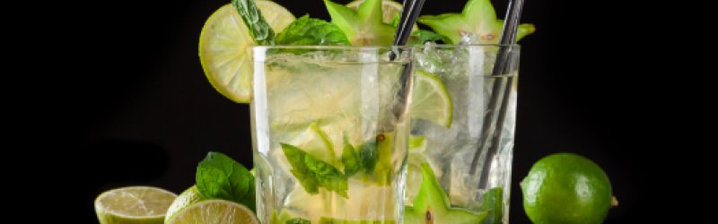 Bild zeigt eine klassische Caipirinha mit Limetten, Rohrzucker und Eis.