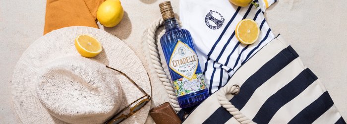 Eine Gin Flasche auf einem Tisch im Garten mit viel Dekoration daneben