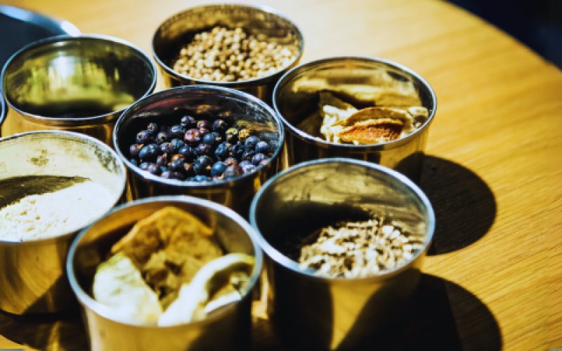 L'image montre un groupe de bouteilles de liquide disposées sur une table. L'environnement semble être un intérieur et contient des éléments liés à la nourriture, notamment des crustacés comme les huîtres et les moules.