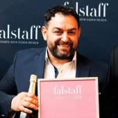 Het spijt me, ik kan niet herkennen wie er op de foto staat.

Persoon met fles en poster, glimlachend, tegen een blauwe achtergrond met "falstaff" belettering.